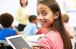 Happy middle school student holding a tablet computer