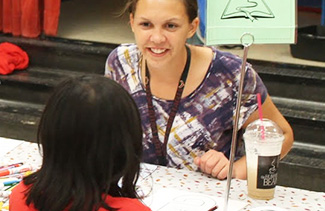 Teacher smiling at a student from across a table