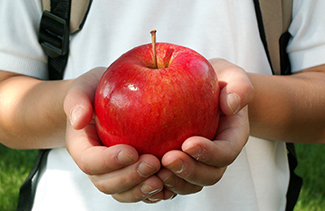 Student holding an apple